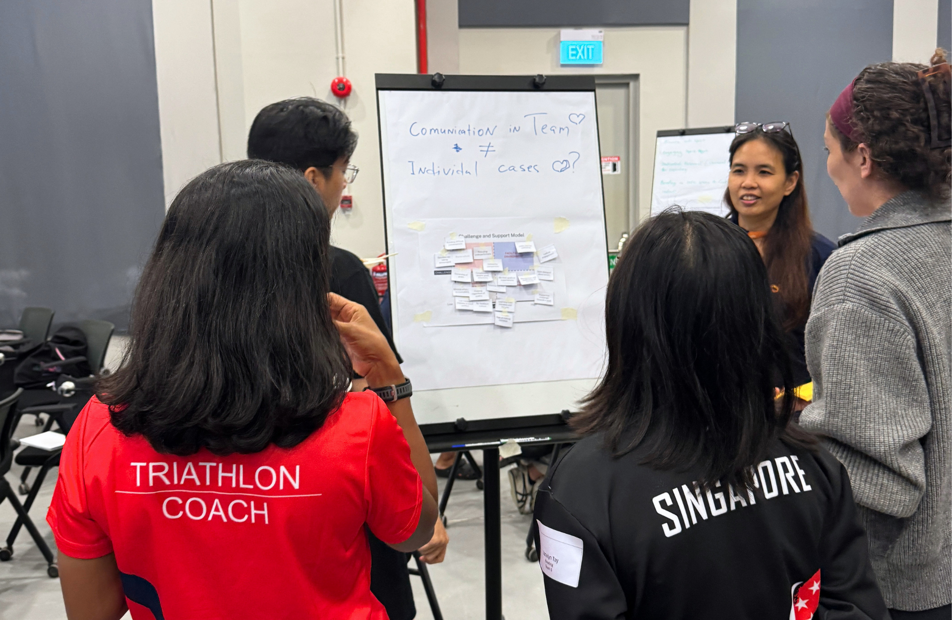 A diverse group of individuals gathered around a whiteboard, discussing ideas and collaborating on a project.